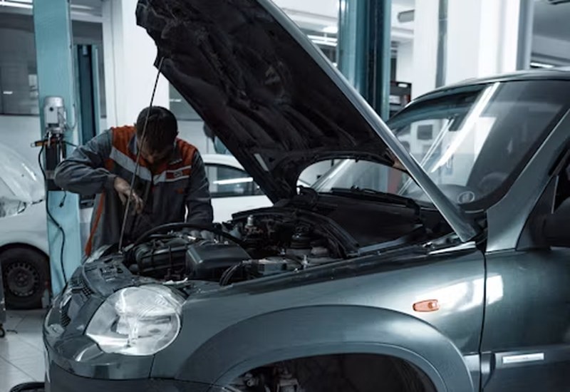 Auto mechanic servicing a car engine in Abuja