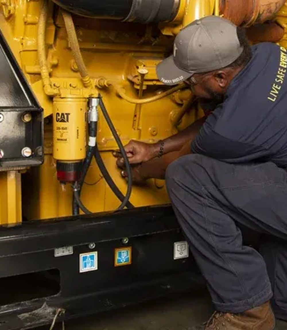Technician servicing a heavy-duty industrial CAT standby generator in Abuja